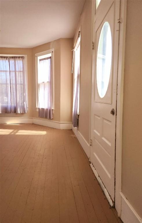 doorway featuring baseboards and wood finished floors