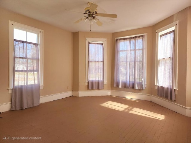 unfurnished room with ceiling fan, wood finished floors, and baseboards