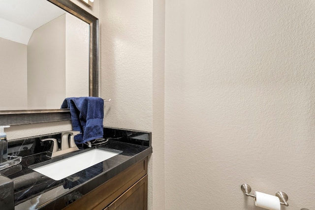 interior space with a textured wall and vanity