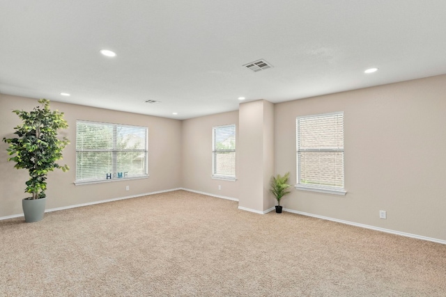 unfurnished room with baseboards, visible vents, light colored carpet, and recessed lighting