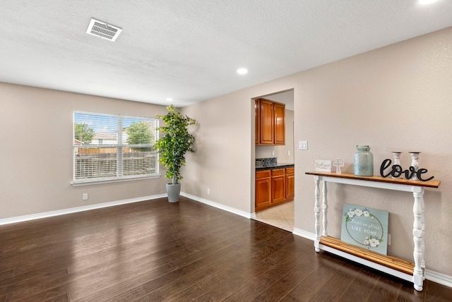 interior space with recessed lighting, visible vents, light wood-style floors, a textured ceiling, and baseboards