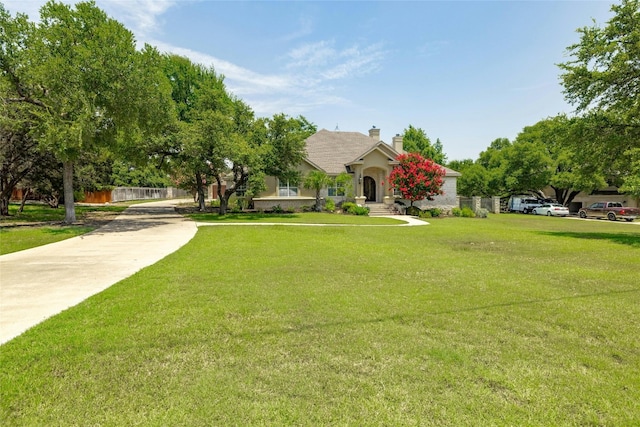 view of front of property with a chimney, fence, and a front lawn