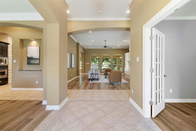 foyer entrance with light wood finished floors, ornamental molding, and baseboards