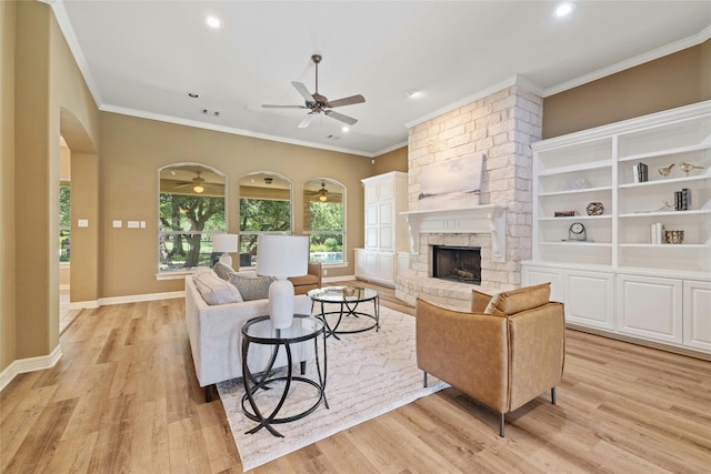 living room with light wood-type flooring, a fireplace, and crown molding