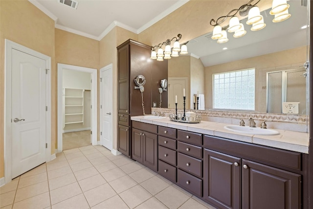 full bath with double vanity, a stall shower, ornamental molding, and a sink