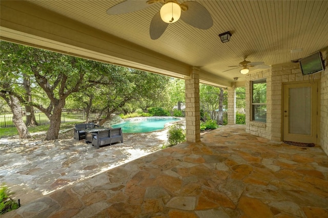 view of patio with fence, an outdoor pool, and a ceiling fan