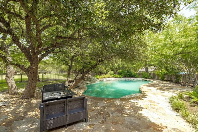 view of swimming pool with a fenced backyard, a fenced in pool, and a patio