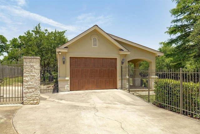 view of front of property featuring a garage, concrete driveway, fence, and stucco siding