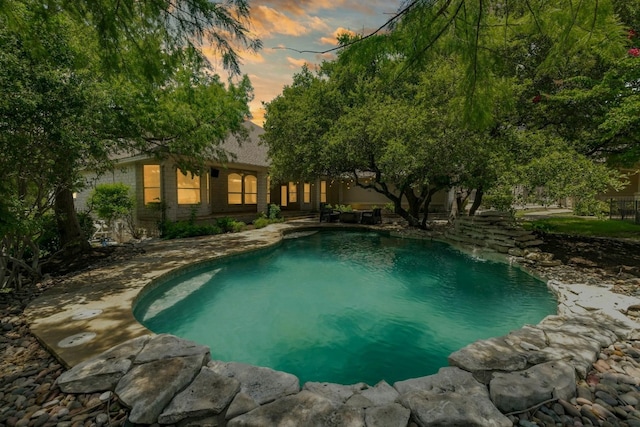 pool at dusk with an outdoor pool