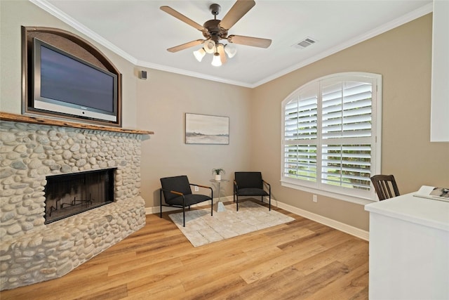 interior space featuring a stone fireplace, wood finished floors, visible vents, baseboards, and crown molding