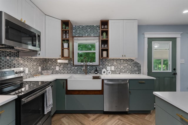 kitchen with open shelves, light countertops, appliances with stainless steel finishes, white cabinets, and a sink