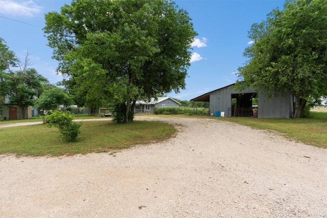 view of road featuring a pole building and dirt driveway