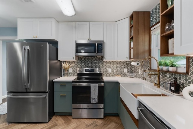 kitchen featuring tasteful backsplash, white cabinets, appliances with stainless steel finishes, light countertops, and open shelves