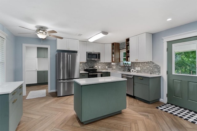 kitchen with white cabinetry, a kitchen island, appliances with stainless steel finishes, and light countertops