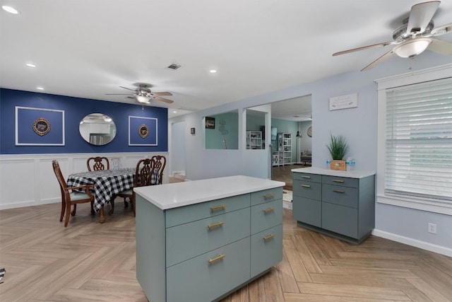 kitchen with recessed lighting, light countertops, visible vents, a ceiling fan, and a kitchen island