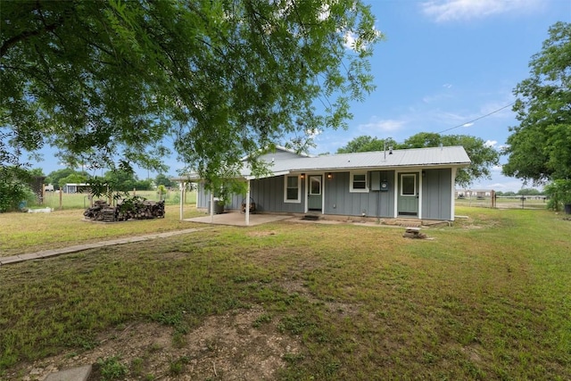 view of front of house featuring fence, a front lawn, and board and batten siding