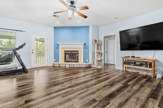 living area with baseboards, a fireplace, a ceiling fan, and wood finished floors