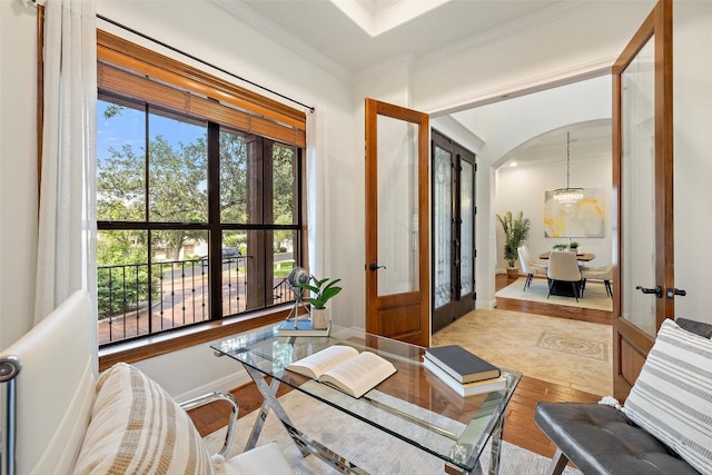 interior space with ornamental molding, french doors, a wealth of natural light, and an inviting chandelier