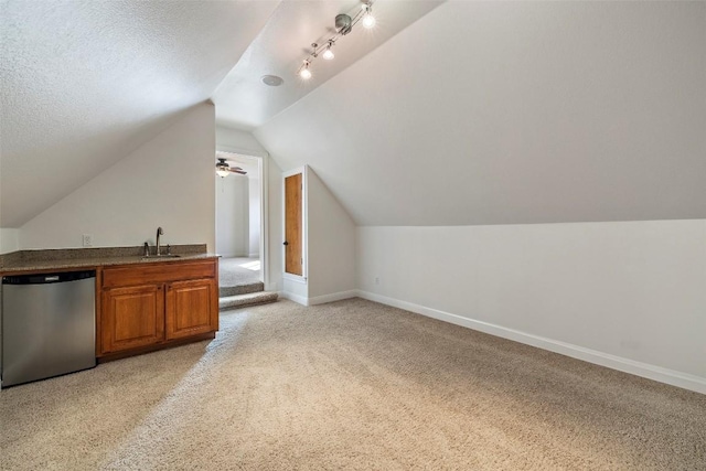 bonus room with lofted ceiling, light colored carpet, a sink, a textured ceiling, and baseboards