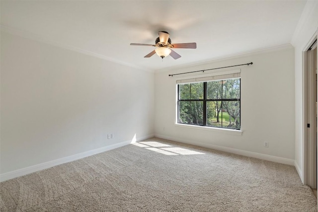 carpeted empty room featuring crown molding, baseboards, and ceiling fan