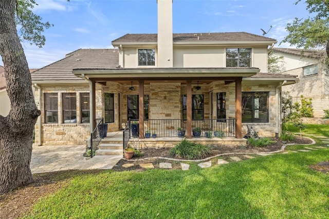 back of house featuring stone siding, a porch, and a ceiling fan