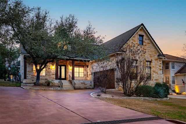 41 Tiburon Dr, The Hills, TX 78738 - view of front facade featuring stone siding, driveway, and covered porch