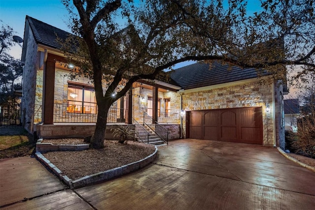 41 Tiburon Dr, The Hills, TX 78738 - view of front of property featuring stone siding, an attached garage, a porch, and concrete driveway