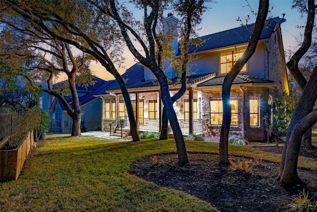 41 Tiburon Dr, The Hills, TX 78738 - rear view of property featuring a yard, stone siding, and stucco siding