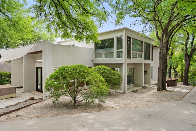 view of side of home with a patio and stucco siding