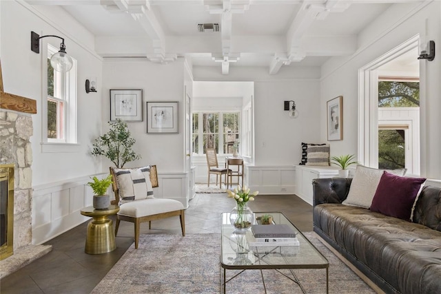 5242 Mccormick Mountain Dr Unit E, Austin, TX 78734 - tiled living area featuring beam ceiling, healthy amount of natural light, a decorative wall, a fireplace, and a wainscoted wall