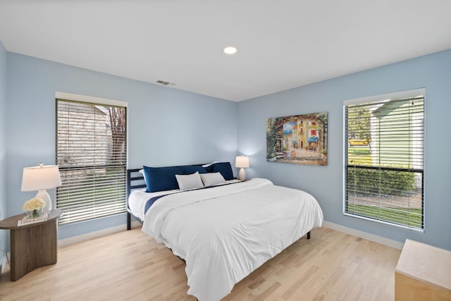 bedroom with baseboards, recessed lighting, visible vents, and light wood-style floors