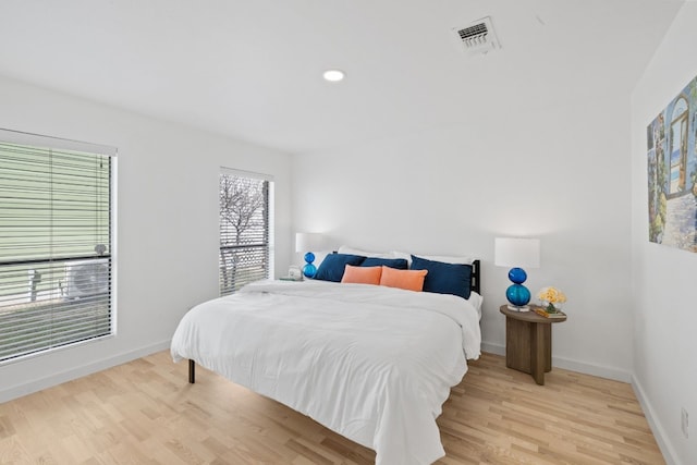 bedroom with light wood-style floors, visible vents, baseboards, and recessed lighting