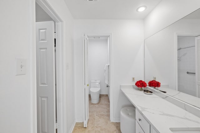 full bath with a closet, toilet, vanity, tile patterned flooring, and baseboards