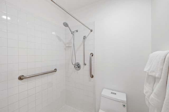 full bath with tiled shower and toilet