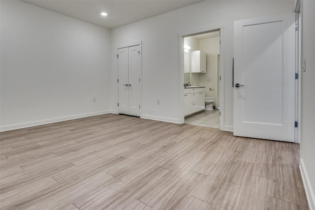 4361 S Congress Ave Unit 504, Austin, TX 78745 - unfurnished bedroom featuring light wood-style floors, connected bathroom, and recessed lighting