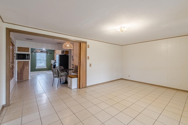 spare room with baseboards and light tile patterned floors