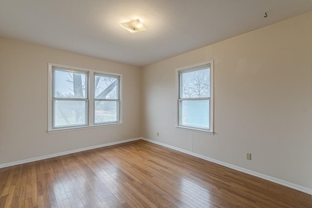 spare room featuring light wood-style flooring and baseboards