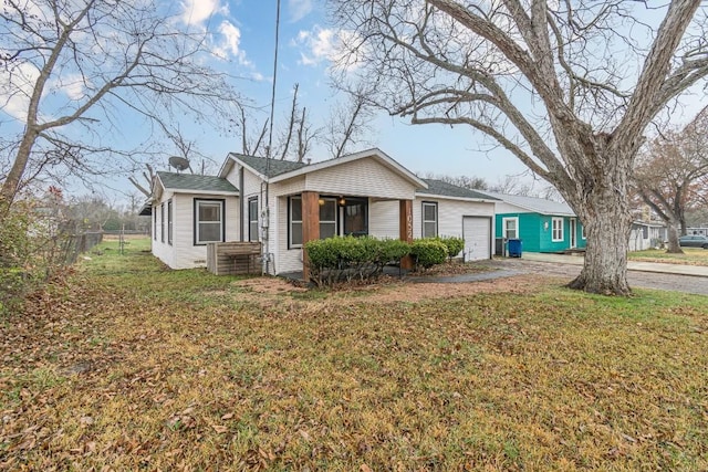 view of front of home featuring a front yard, driveway, an attached garage, and fence