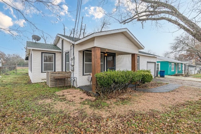 view of front of property with driveway, an attached garage, and fence