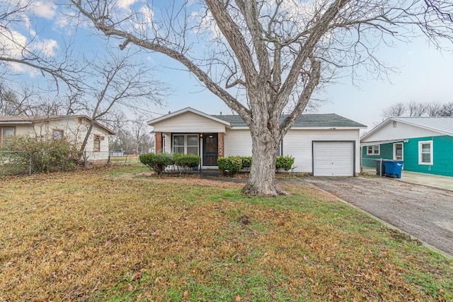 view of front of property featuring a garage, driveway, a front yard, and fence