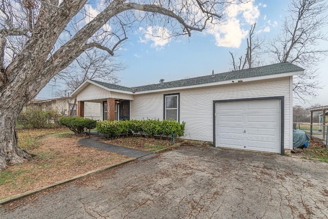 single story home featuring an attached garage and aphalt driveway