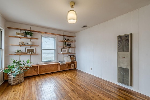 interior space featuring a heating unit, wood finished floors, and visible vents