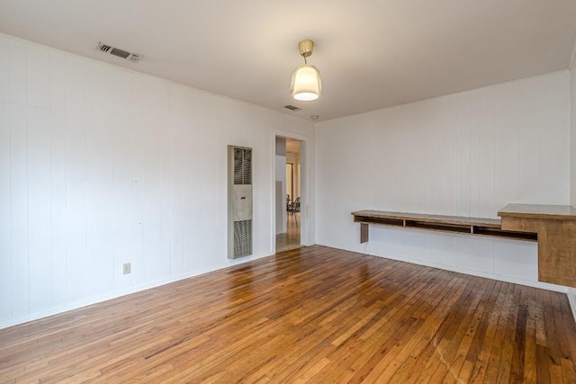 unfurnished room with visible vents and wood finished floors