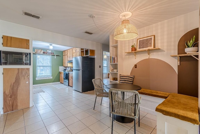 dining area with light tile patterned floors and visible vents