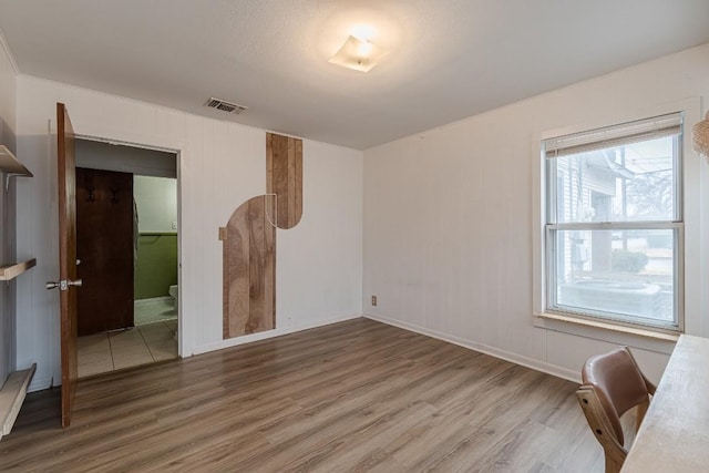 interior space with baseboards, visible vents, and wood finished floors