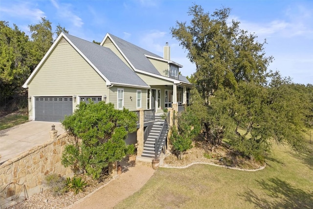 view of front of house featuring a porch, a garage, stairs, driveway, and a chimney