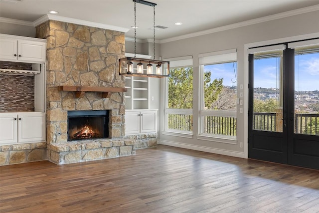 unfurnished living room with dark wood-style floors, crown molding, and a stone fireplace