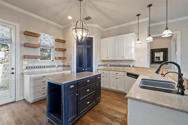 kitchen with pendant lighting, white cabinets, a sink, and open shelves