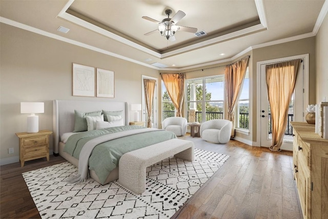 bedroom featuring visible vents, access to exterior, ornamental molding, light wood-type flooring, and a raised ceiling