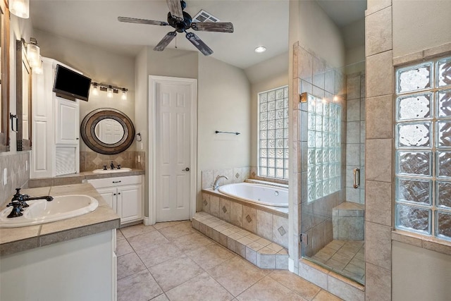 full bath featuring double vanity, a garden tub, a shower stall, and a sink